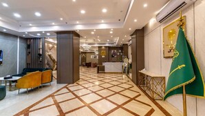 A hotel lobby with a check-in counter, seating area, and a patterned floor. - Gardenia Park Al Zahraa Serviced Apartments (Economy) (Jeddah)