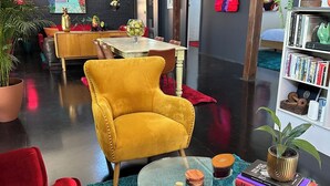 A modern living room with a yellow armchair, red sofas, a glass coffee table, and a bookshelf. - Palm Springs retreat Hunter Valley (Aberdare)