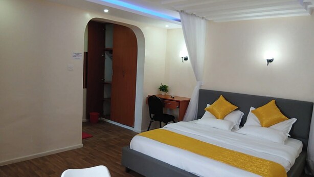 Une chambre d’hôtel avec un lit, un bureau et une chaise.
