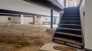 A staircase leading to a higher level with a sandy area in the foreground. - Lyon Mountain Lodge (Saranac)