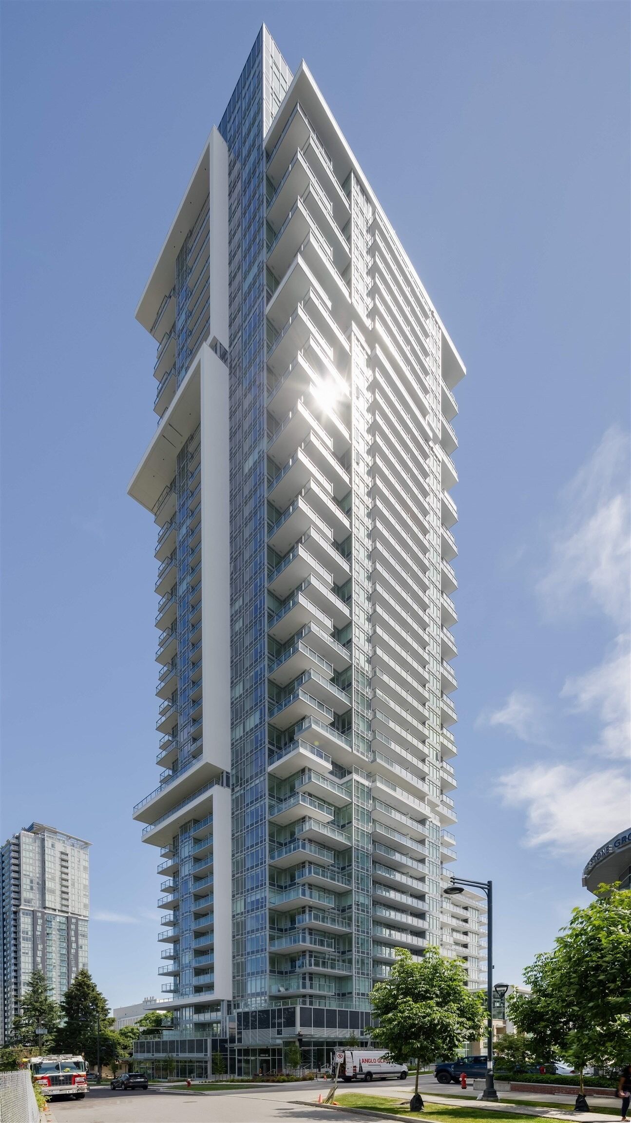 Un immeuble moderne de grande hauteur, doté de nombreux balcons et de grandes fenêtres.
