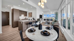Una cocina moderna con armarios de madera oscura, encimera blanca y horno empotrado.