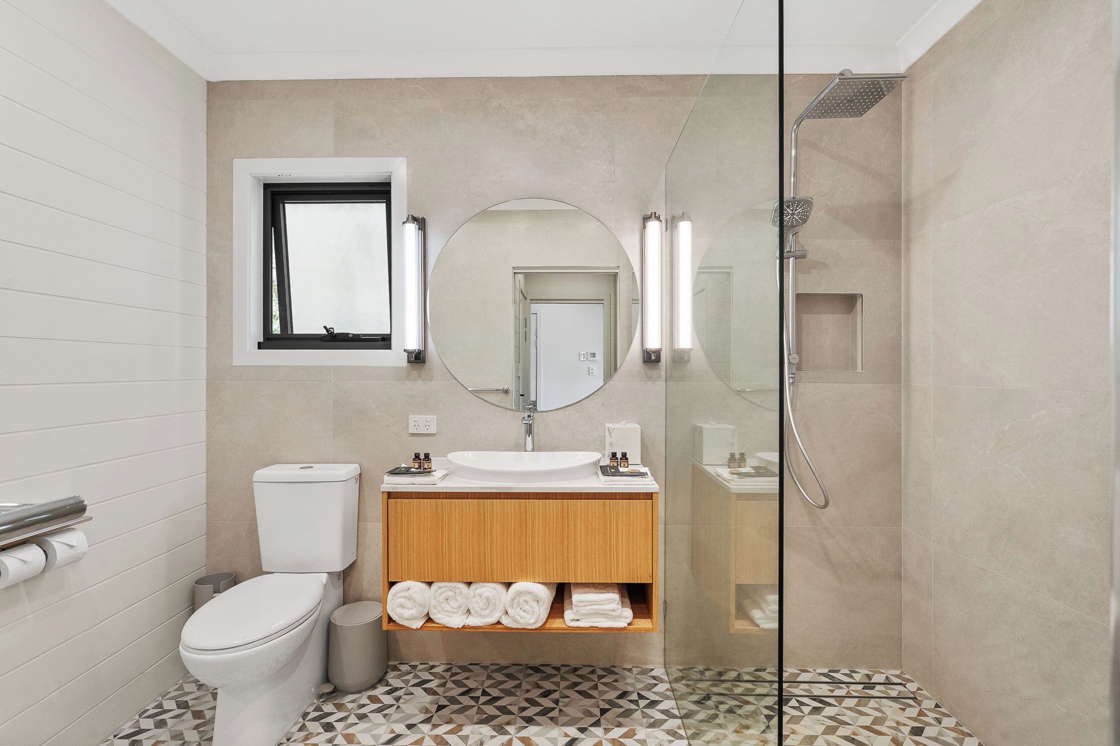 A modern bathroom with a toilet, sink, and shower.