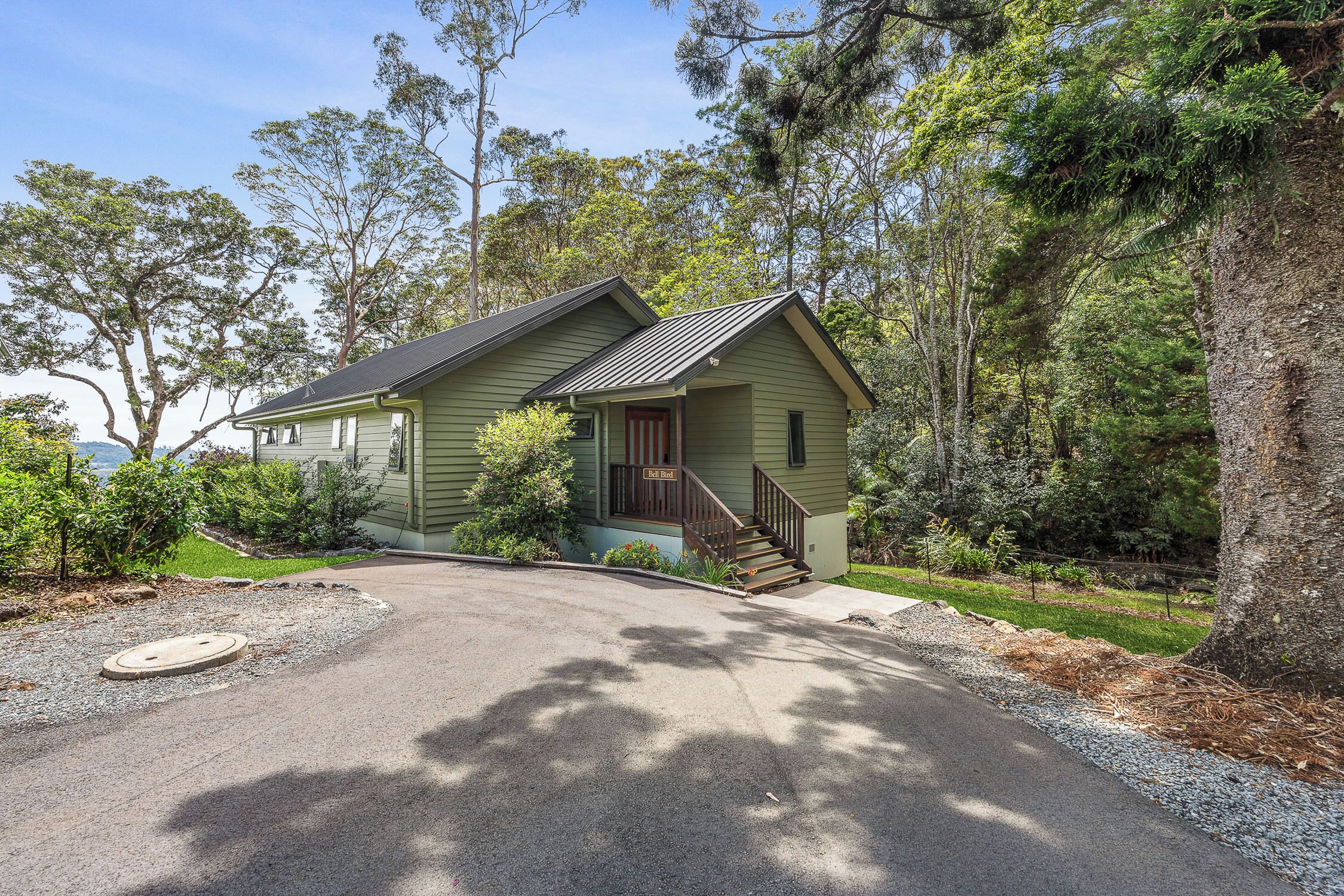 A two-story house with a front porch, a staircase, and a driveway.