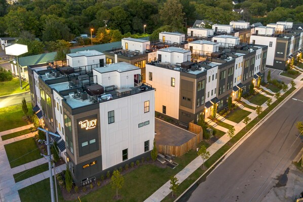 A modern multi-story building with a flat roof, large windows, and a sign reading "The Lucy".