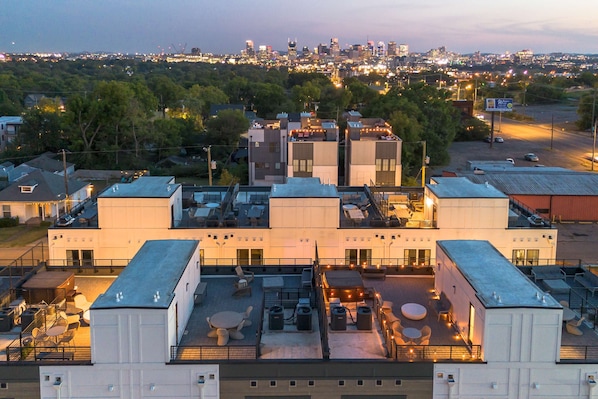 Une terrasse sur le toit avec des places assises extérieures, une vue sur le panorama urbain et un espace de stationnement.