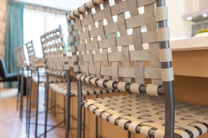 Une rangée de chaises dotées d’un dossier en osier et d’une structure en métal, disposées dans un coin repas.