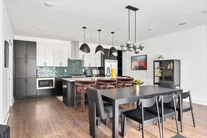 A modern kitchen with dark cabinets, a central island, and pendant lighting.
