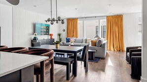 A modern living room with a sofa, dining table, and chairs.