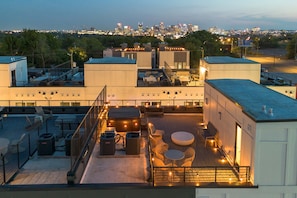 A rooftop terrace with outdoor seating, air conditioning units, and a city skyline view in the background. - Two rooftop homes with hot tub & fire pit, sleeps 20 near Broadway, Nashville (Nashville)