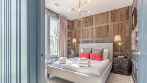 Una camera da letto moderna con un letto grande, una parete decorata in legno e vista sull'esterno.