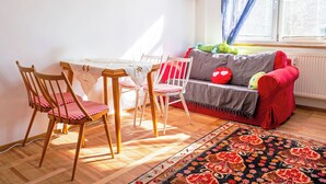 Une pièce chaleureuse avec une table à manger, des chaises, un canapé et un tapis à motifs.
