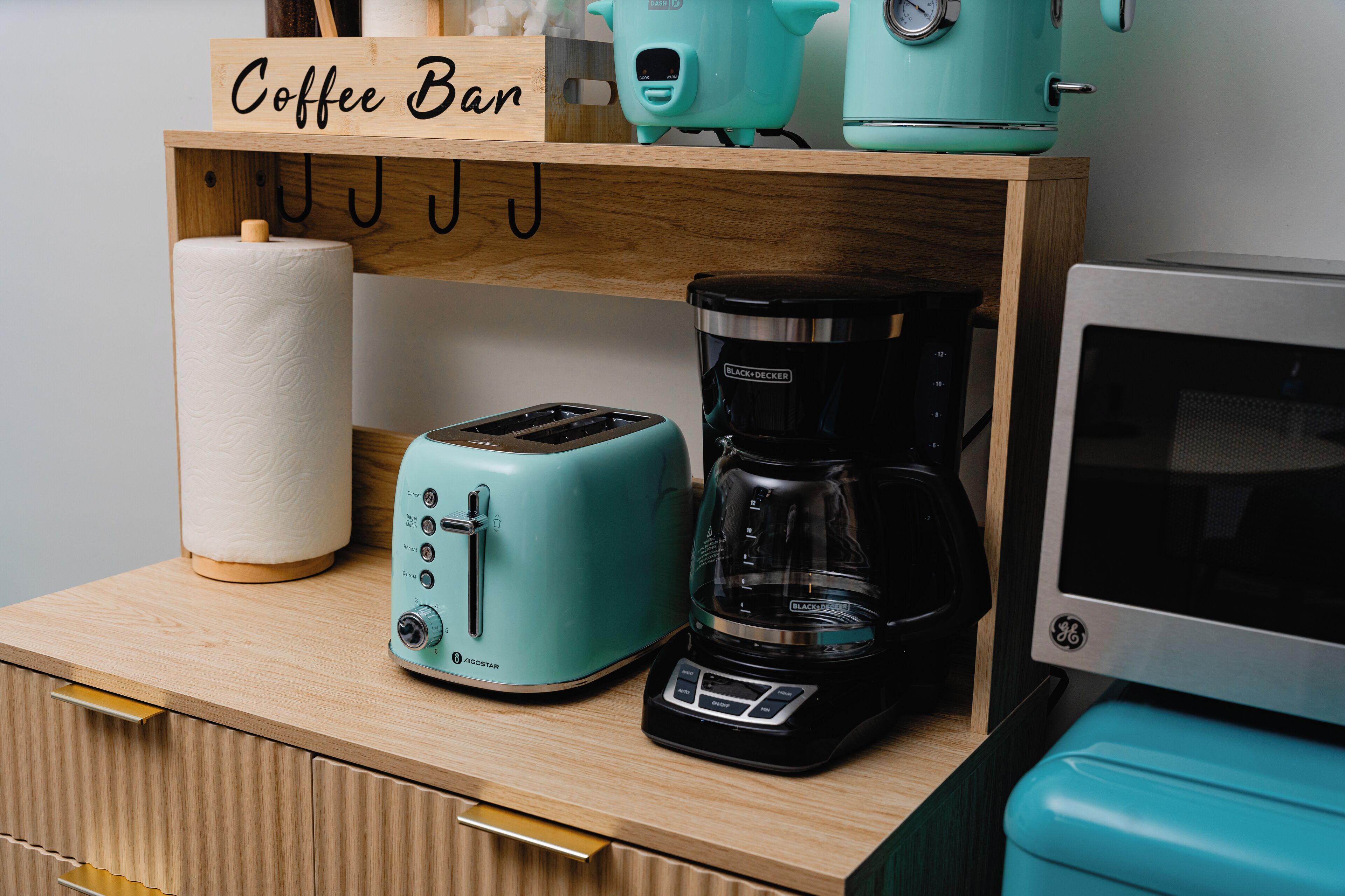 En køkkenbordplade med kaffemaskine, brødrister og et skilt der står 'Coffee Bar'.