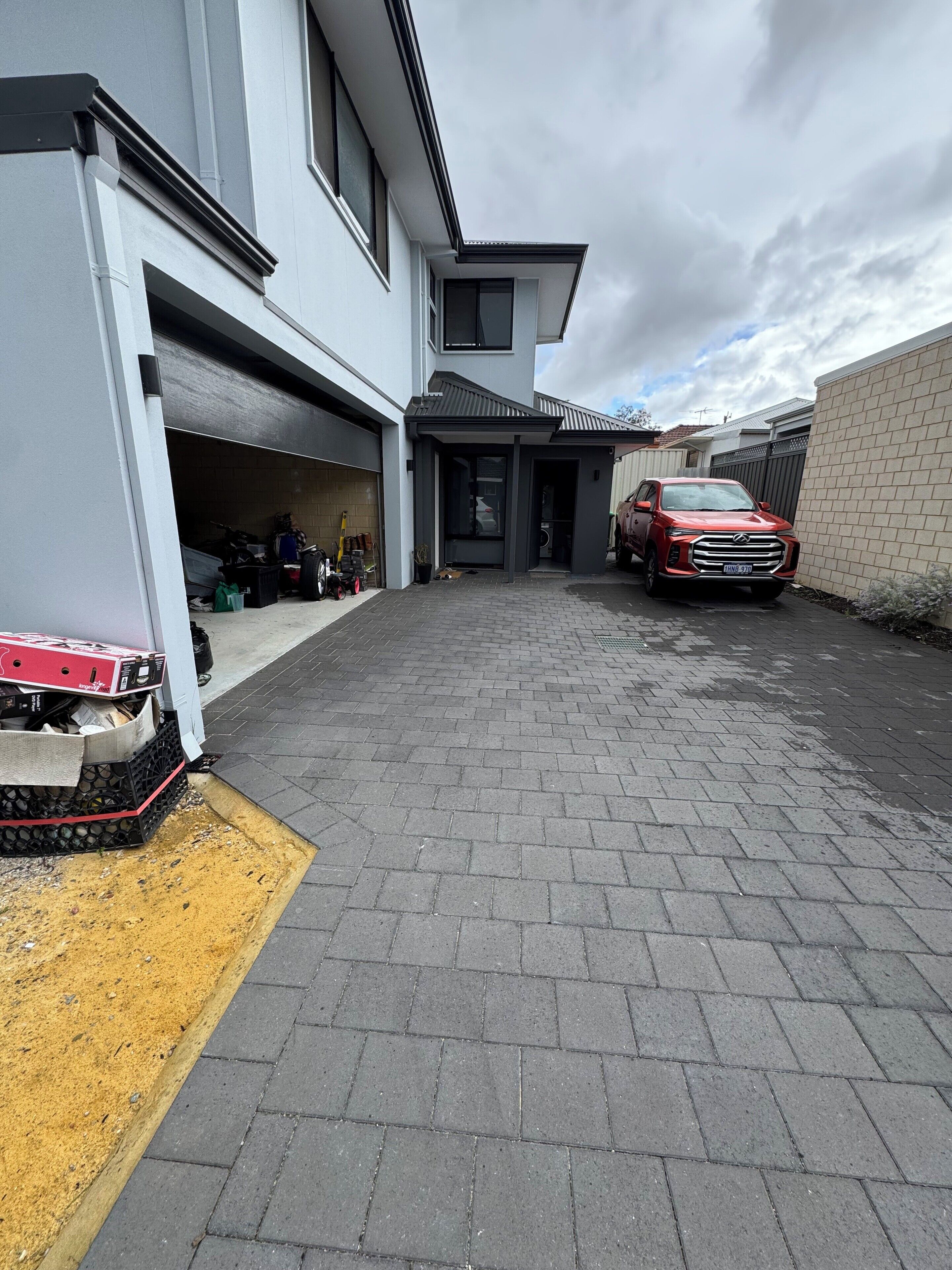 A modern house with a garage, a driveway, and a parked car.