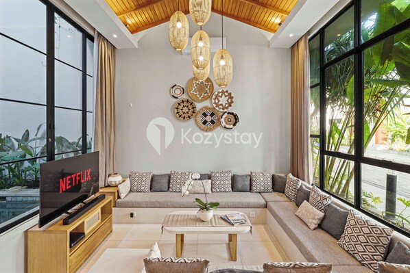 A modern living room with a sofa, television, and decorative wall art. - Artland Villa by Kozystay - Canggu (Canggu)