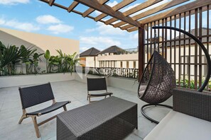 A patio with wicker furniture, a hanging chair, and a pergola. - Artland Villa by Kozystay - Canggu (Canggu)