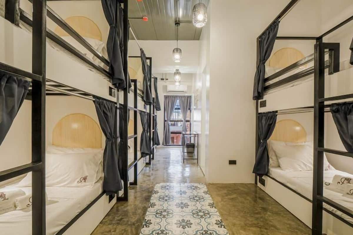 Un corridoio con letti a castello, un tappeto decorato e un lampadario.