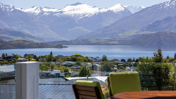 A view of a lake with mountains in the background and houses in the foreground. - Amazing views of Lake and Mountains on Bovett (Wānaka)