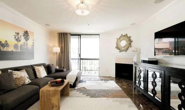 A living room with a sofa, coffee table, and a fireplace.
