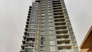 Un edificio de apartamentos alto y moderno, con varios balcones y fachada de vidrio.