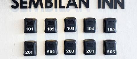 A wall with room numbers and the text 'SEMBILAN INN' indicating a hotel.