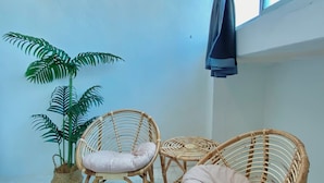 A room with two wicker chairs, a potted plant, and a window with curtains. - Sembilan Inn by Soft loft (George Town)