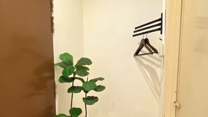 A small, narrow hallway with a brown door on the left, a white wall, and a small shelf with a woven basket. - Sembilan Inn by Soft loft (George Town)