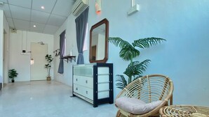 A hallway with a mirrored wardrobe, wicker chairs, and a potted plant. - Sembilan Inn by Soft loft (George Town)