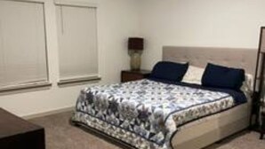 Ein Schlafzimmer mit einem Bett, einem Nachttisch und einem Fenster.