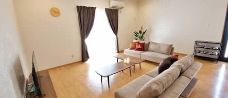 A living room with a sofa, coffee table, and a TV on a wooden stand.