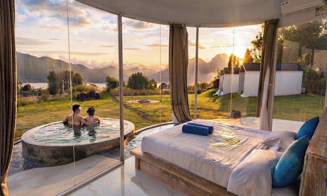 Una camera da letto con un letto grande, una vasca idromassaggio e vista su un paesaggio montuoso.