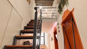 A staircase with a wooden finish, a metal railing, and a plant on the right side. - Cozy in the historic center of Palermo 300mt from the train station (Palermo)
