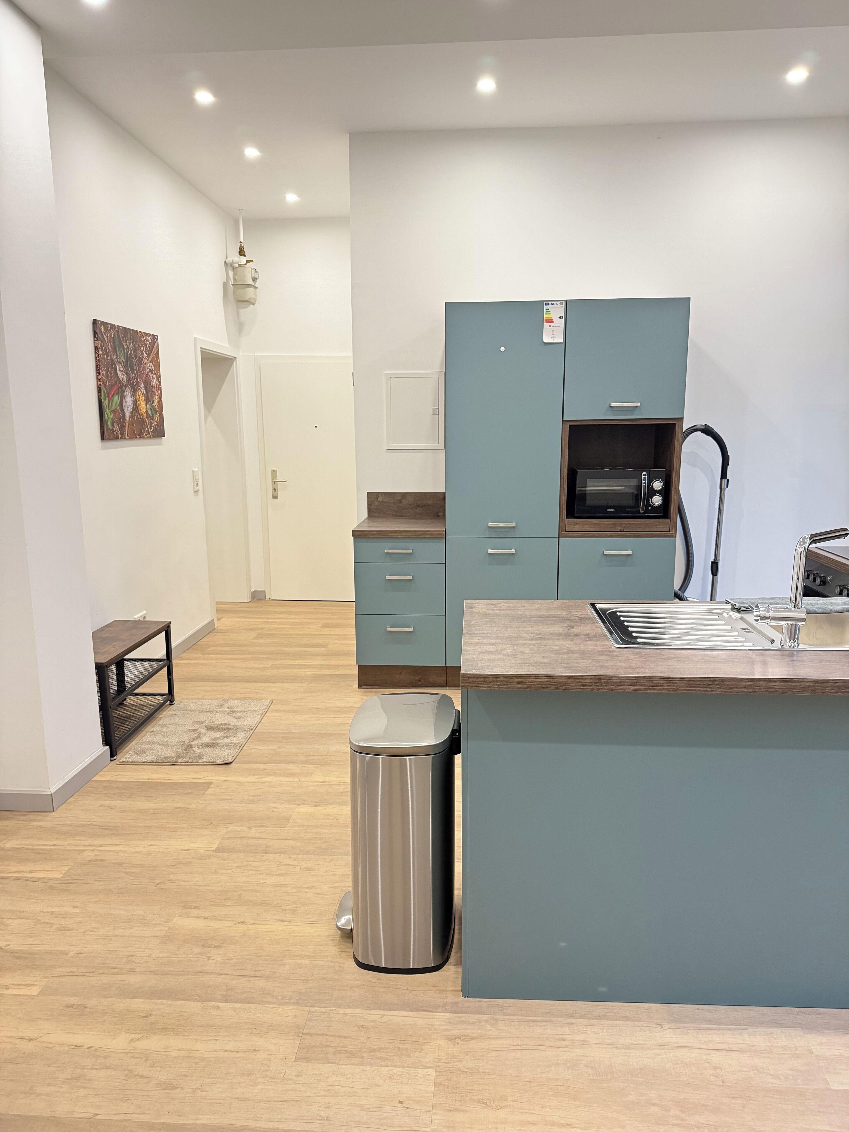 Une cuisine moderne dotée d’un îlot central, d’un four à micro-ondes et d’un évier.