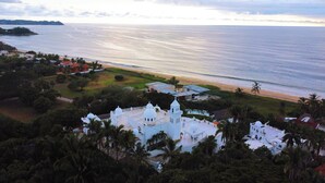 A white building with domed structures, surrounded by palm trees and a beach. - Penthouse with pool and ocean view just a few steps from the beach (San Francisco)