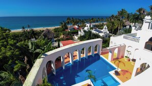 A resort with a pool, beach view, and tropical vegetation. - Penthouse with pool and ocean view just a few steps from the beach (San Francisco)