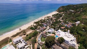 An aerial view of a coastal town with a beach, houses, and a large white building with domed structures. - Penthouse with pool and ocean view just a few steps from the beach (San Francisco)