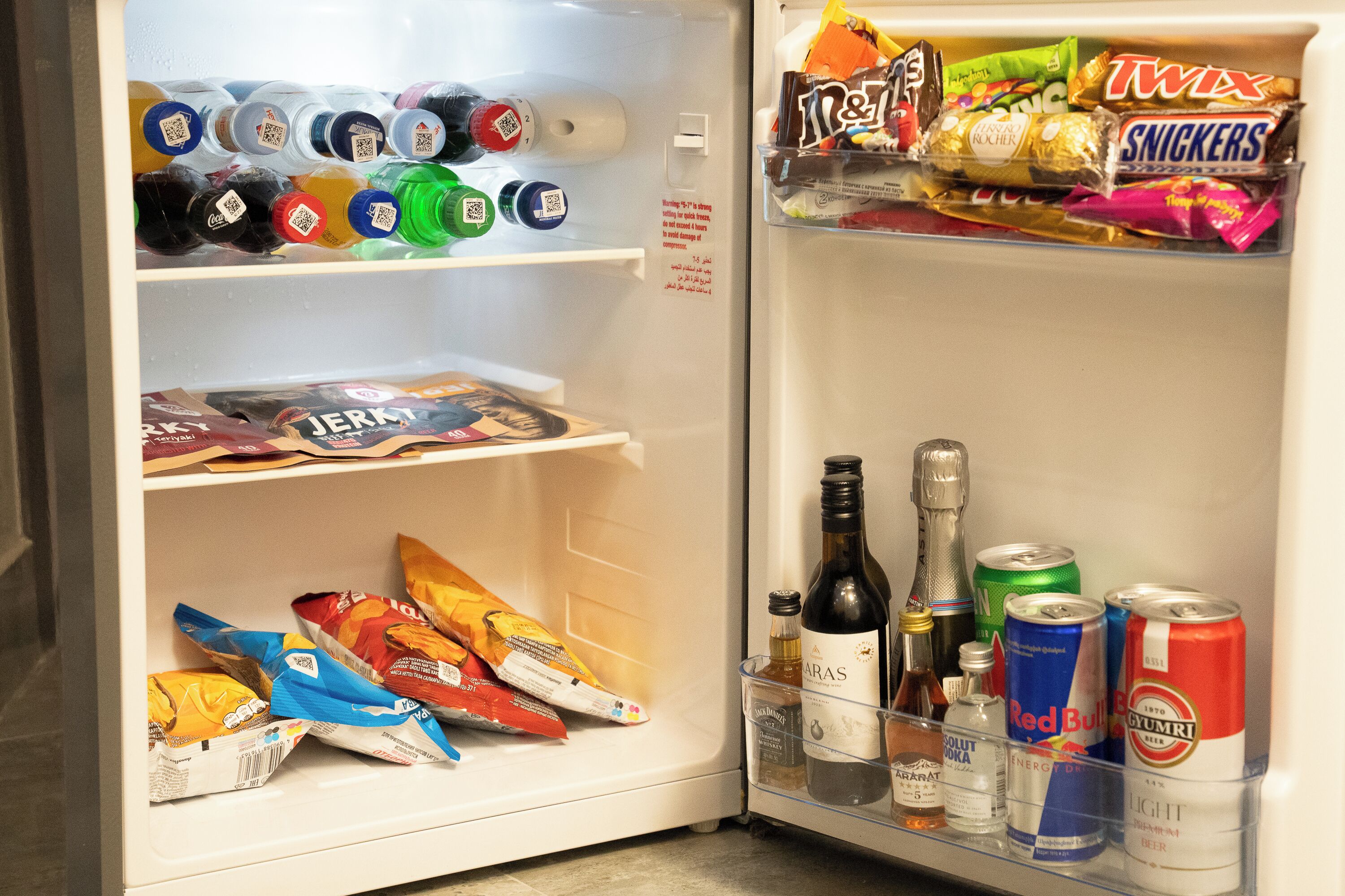 A refrigerator stocked with beverages, snacks, and drinks.