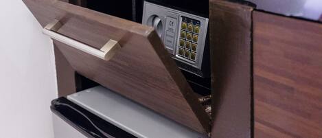 A compact kitchenette with a coffee maker, a cup, and a kettle on the counter.