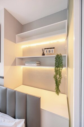 A modern interior with built-in shelving, a date calendar, and a potted plant.