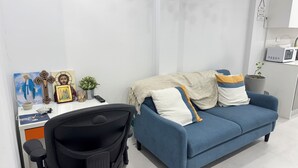 Un espace de bureau moderne comprenant un bureau, une chaise et un canapé bleu.