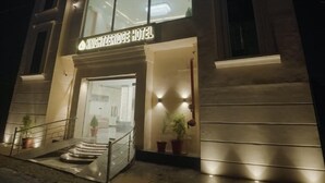 The Knightbridge Hotel at night with illuminated signage, a modern facade, and a staircase leading to the entrance. - Knightz bridge (Faizabad)