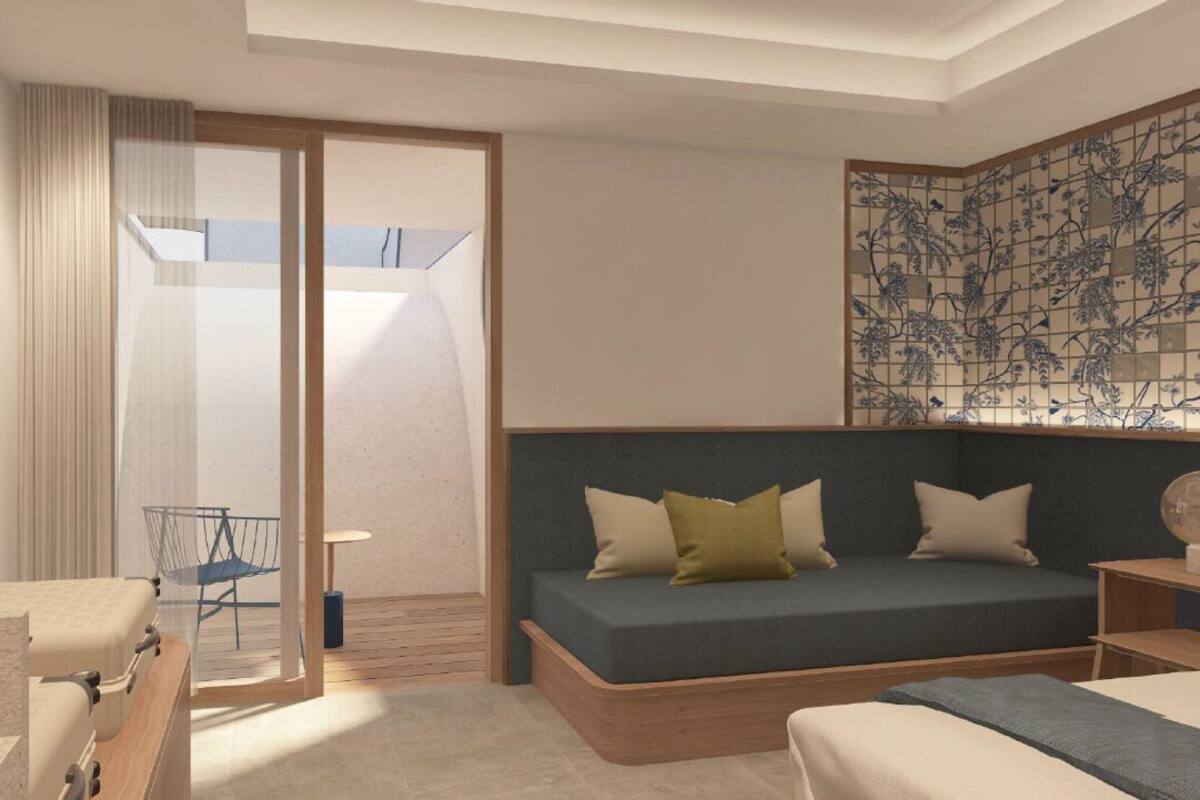 Una habitación de hotel moderna con sofá cama, una mesita, una silla y un panel decorativo en la pared.