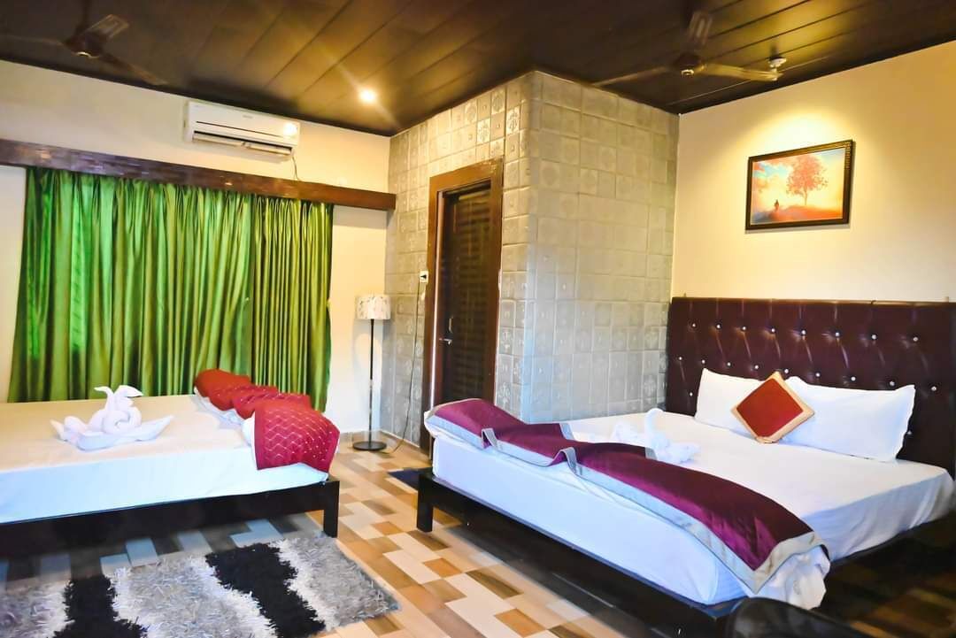 A hotel room with two beds, a stone wall, a painting, and a checkered floor.