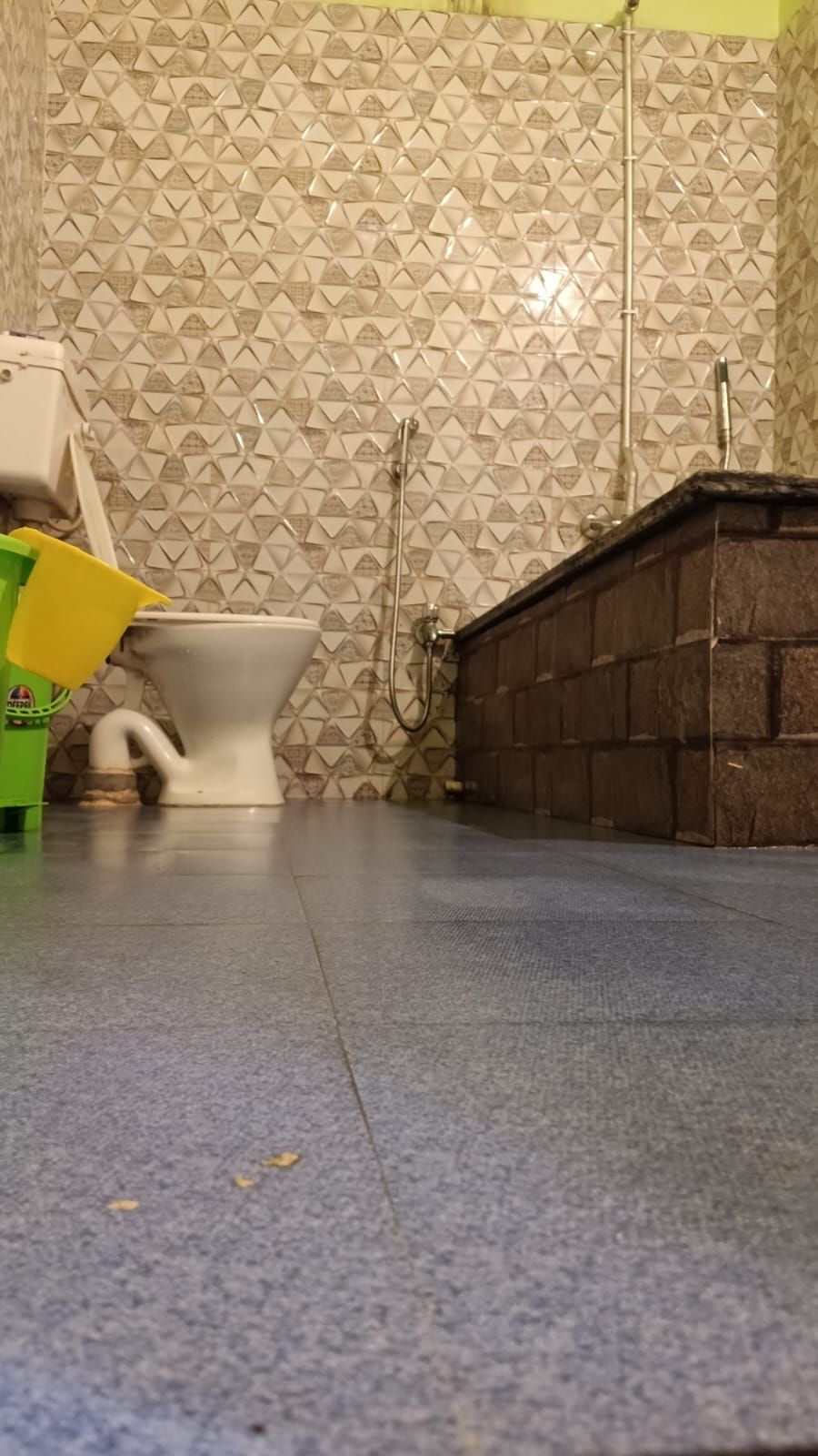 Un bagno con carta da parati decorata, un water, una doccia e un lavandino.