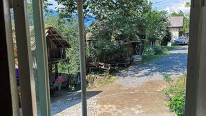 Ein rustikales Holzgebäude mit einem Strohdach, einem Kiesweg und einer Pflasterfläche.