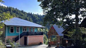 Ein rustikales Haus mit blauem Dach, einem Backsteingrund und einem Schotterweg.