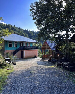 A rustic house with a blue roof, a brick lower section, and a gravel driveway. - Tremendous villa with AC in Akutsa - 5 bedrooms for a perfect getaway (keda)
