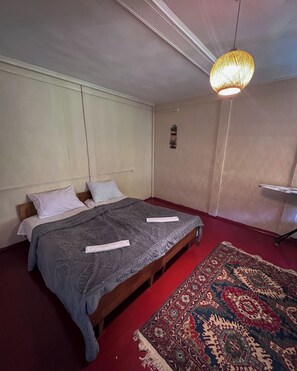 A bedroom with a bed, a red carpet, and a patterned rug. - Tremendous villa with AC in Akutsa - 5 bedrooms for a perfect getaway (keda)