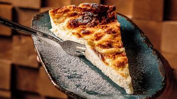 Una porción de tarta sobre un plato de cerámica con un fondo de madera.