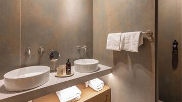 Un baño moderno con dos lavamanos amplios, un espejo y un perchero para toallas.